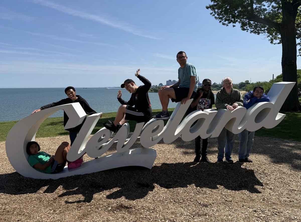 Hub members posing together on the Cleveland sign by Lake Erie